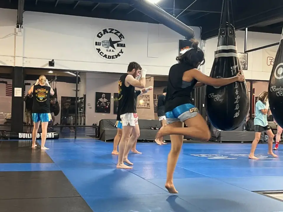 A Muay Thai class throwing knees on heavy bags at Gazze Academy