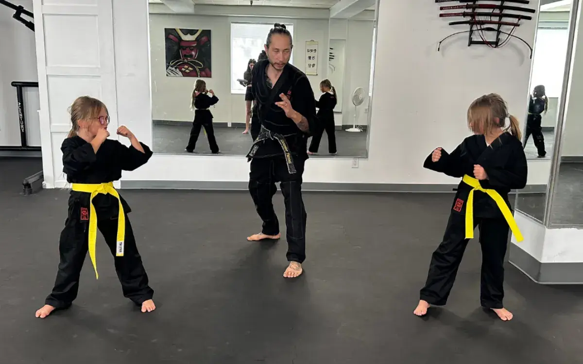 Alex teaching two young students in black uniforms at Street Fighters Martial Arts Academy